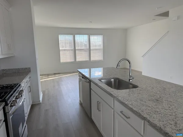 a kitchen with sink a stove and cabinets