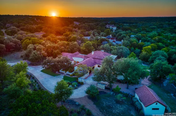 an aerial view of residential houses with outdoor space and trees