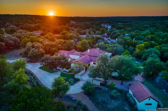 an aerial view of residential houses with outdoor space and trees