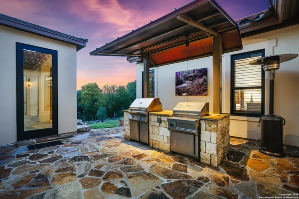 a kitchen with stainless steel appliances kitchen island granite countertop a table chairs and a refrigerator