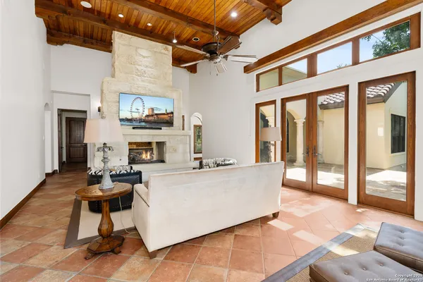 a living room with furniture a fireplace and a floor to ceiling window