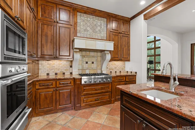 a kitchen with stainless steel appliances granite countertop a refrigerator and a sink
