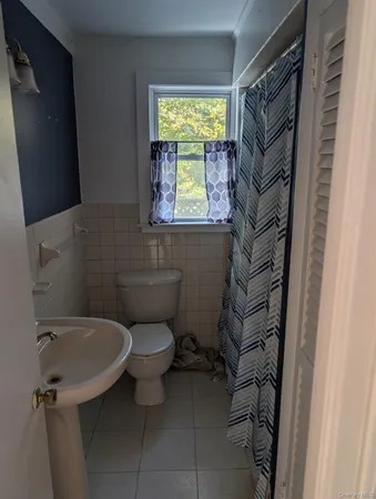 a bathroom with a toilet sink and window