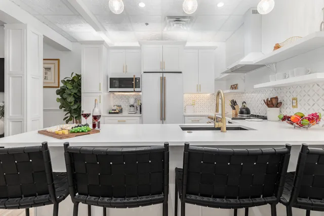 a kitchen with a sink dining table and chairs