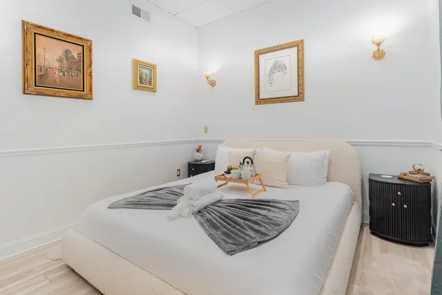 a bedroom with a bed and painting on the wall