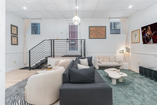 a living room with furniture and a chandelier