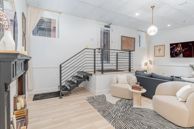 a living room with furniture a flat screen tv and a wall painting