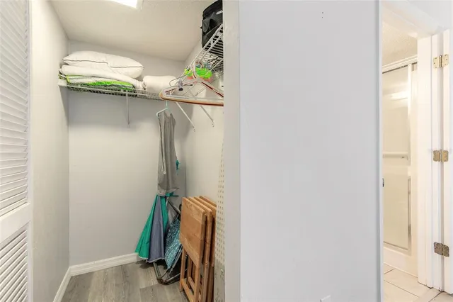 a view of walk in closet with clothes and shoes