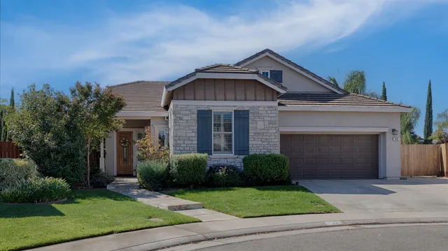 a front view of a house with a garden and garage