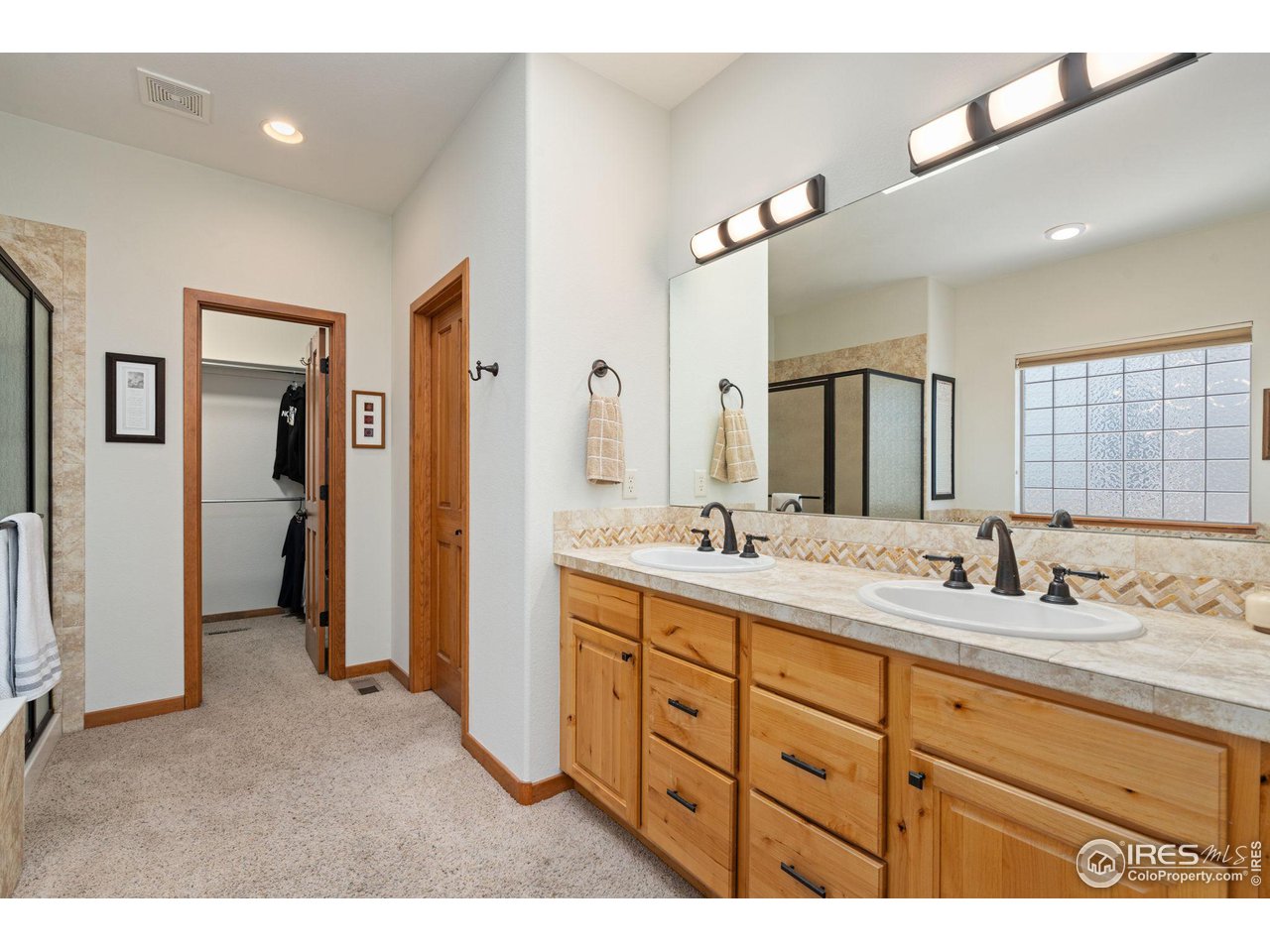 6747 Spanish Bay Drive Windsor, CO 80550 - Photo 17 of 30 a bathroom with a double vanity sink and mirror