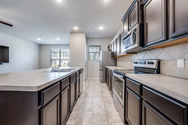 a kitchen with stainless steel appliances granite countertop a sink and dishwasher a stove top oven with wooden floor