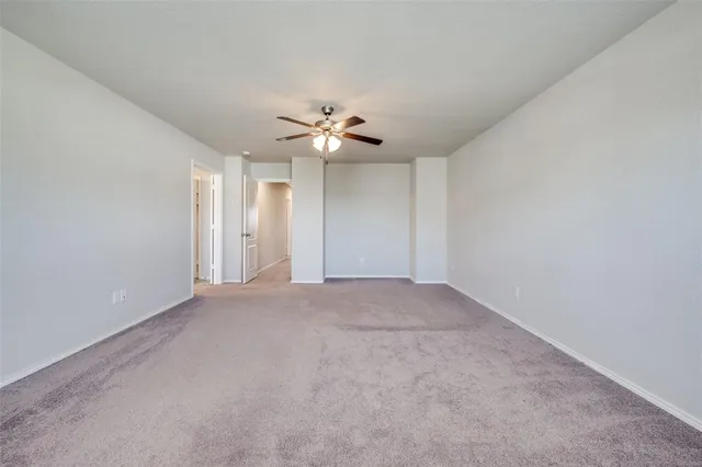 a view of an empty room with a ceiling fan