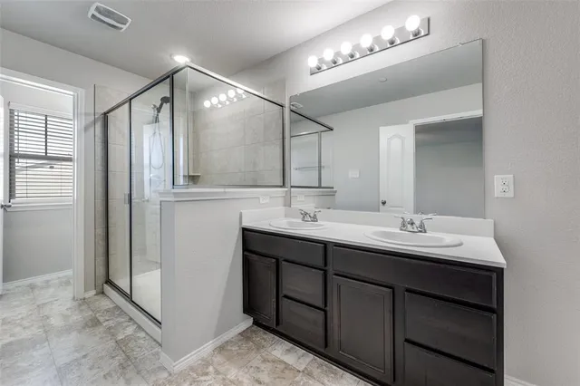 a bathroom with a double vanity sink and a mirror