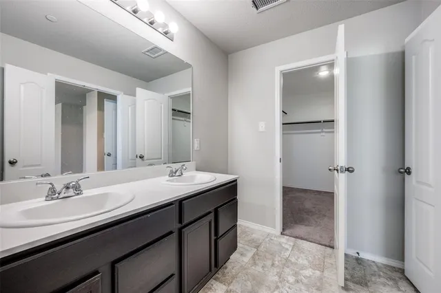 a bathroom with a granite countertop sink a mirror and a shower