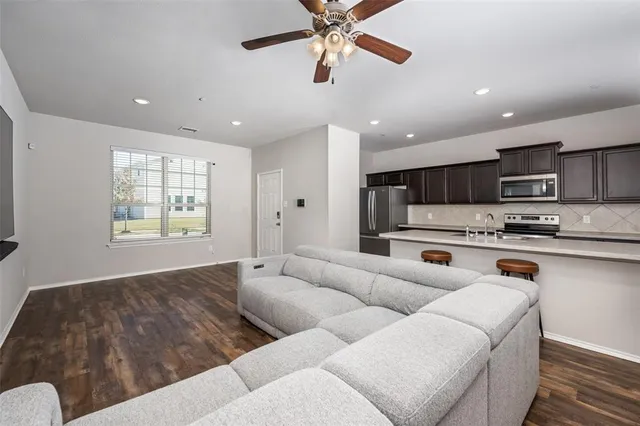 a living room with stainless steel appliances kitchen island granite countertop furniture and a window