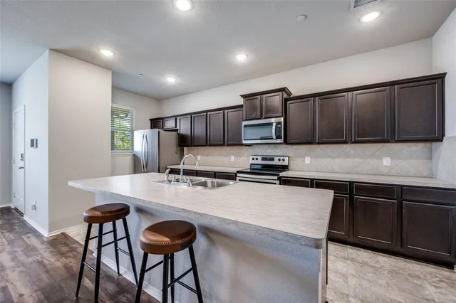 a kitchen with stainless steel appliances a stove a sink a microwave and cabinets