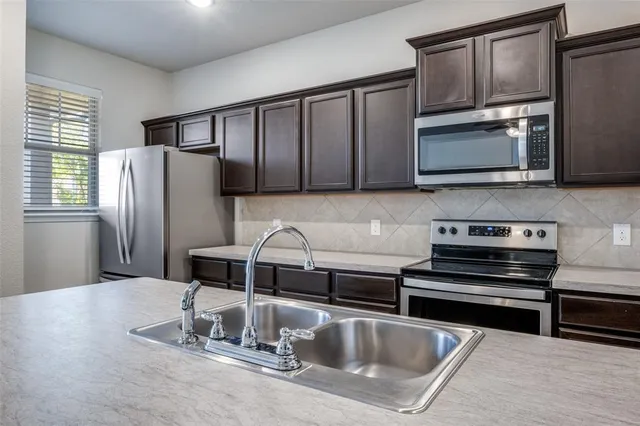 a kitchen with a refrigerator stove and microwave