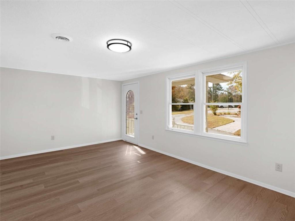 296 Reeves Road Jackson, GA 30233 - Photo 19 of 78 an empty room with wooden floor and windows