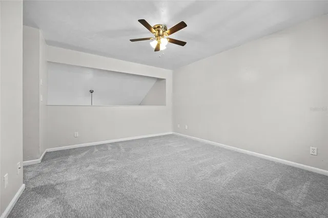 an empty room with closet and ceiling fan