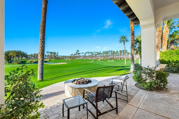 a view of a chairs and table in patio with a yard