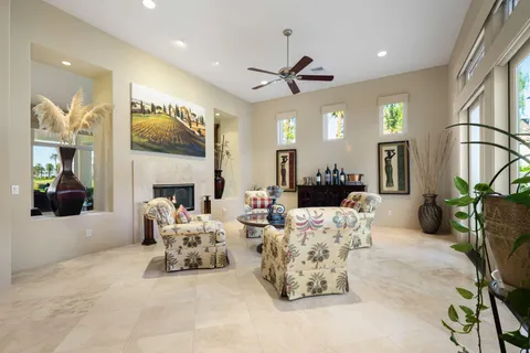 a living room with furniture a fireplace and a chandelier