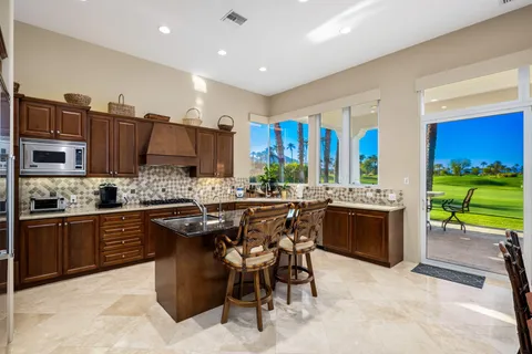 a kitchen with stainless steel appliances granite countertop a stove a sink dishwasher and a refrigerator