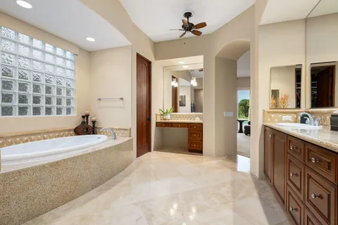 a spacious bathroom with a tub sink shower and mirror