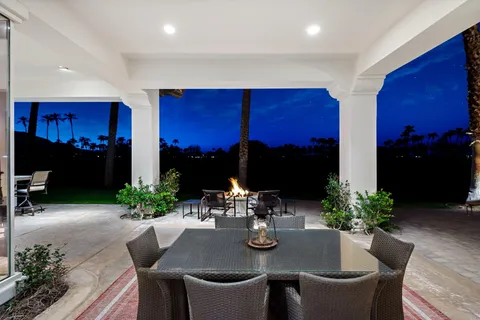 a dining room with furniture a potted plant and wooden floor