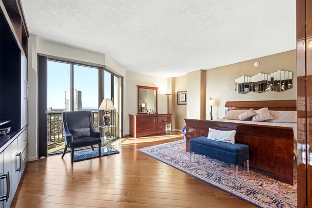 a bed room with a bed a flat screen tv and a dresser