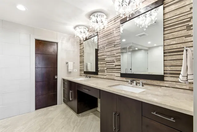 a bathroom with a granite countertop sink a mirror a bathtub and shower