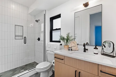 a bathroom with a sink a toilet and shower