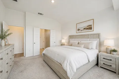 a bedroom with a bed and a lamp on dresser