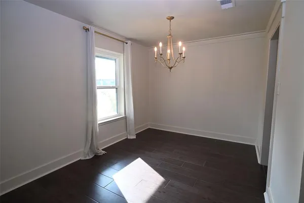 an empty room with wooden floor and window