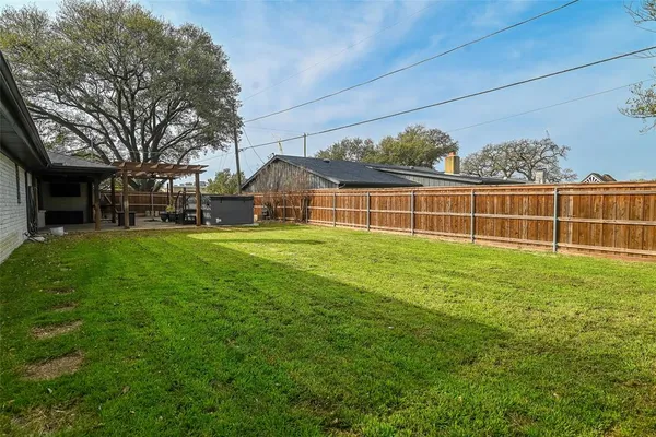 a view of a house with a yard and large tree