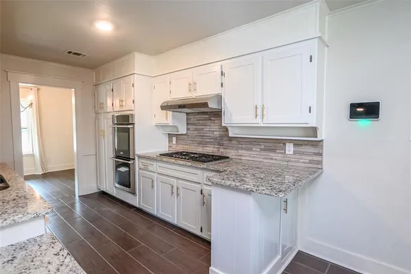 a kitchen with stainless steel appliances granite countertop a stove a refrigerator and a sink