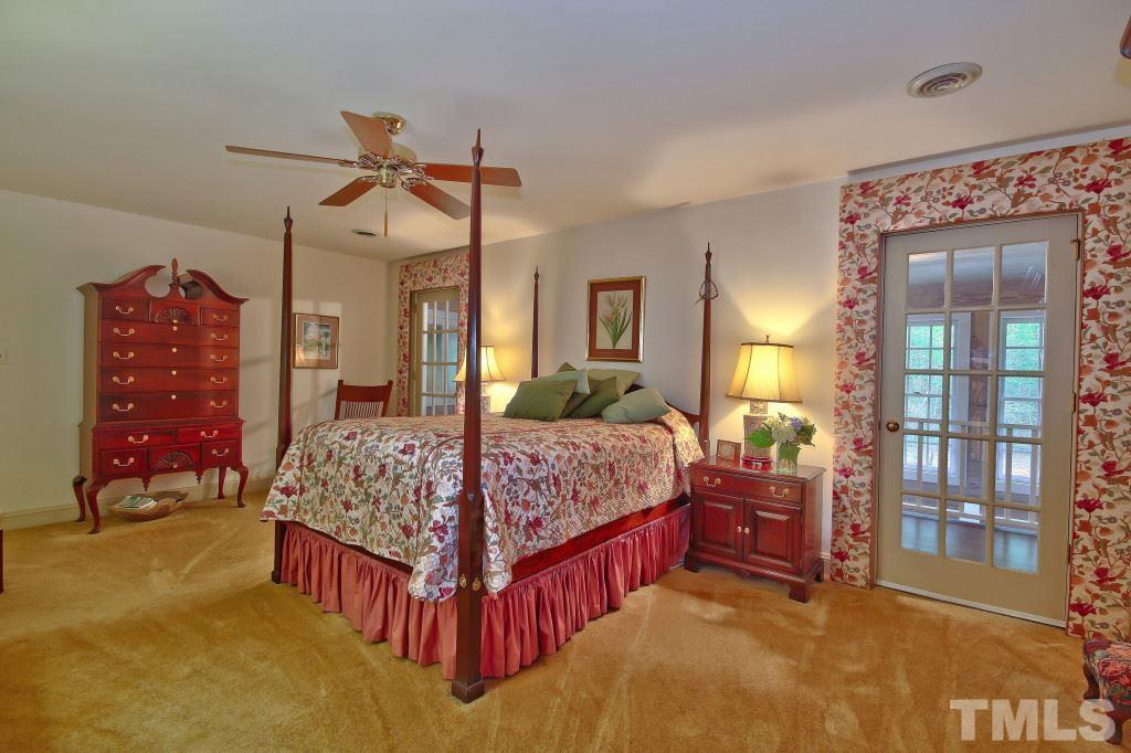 6257 Moore Road Red Oak, NC 27856 - Photo 14 of 25 a bedroom with a bed and a chandelier