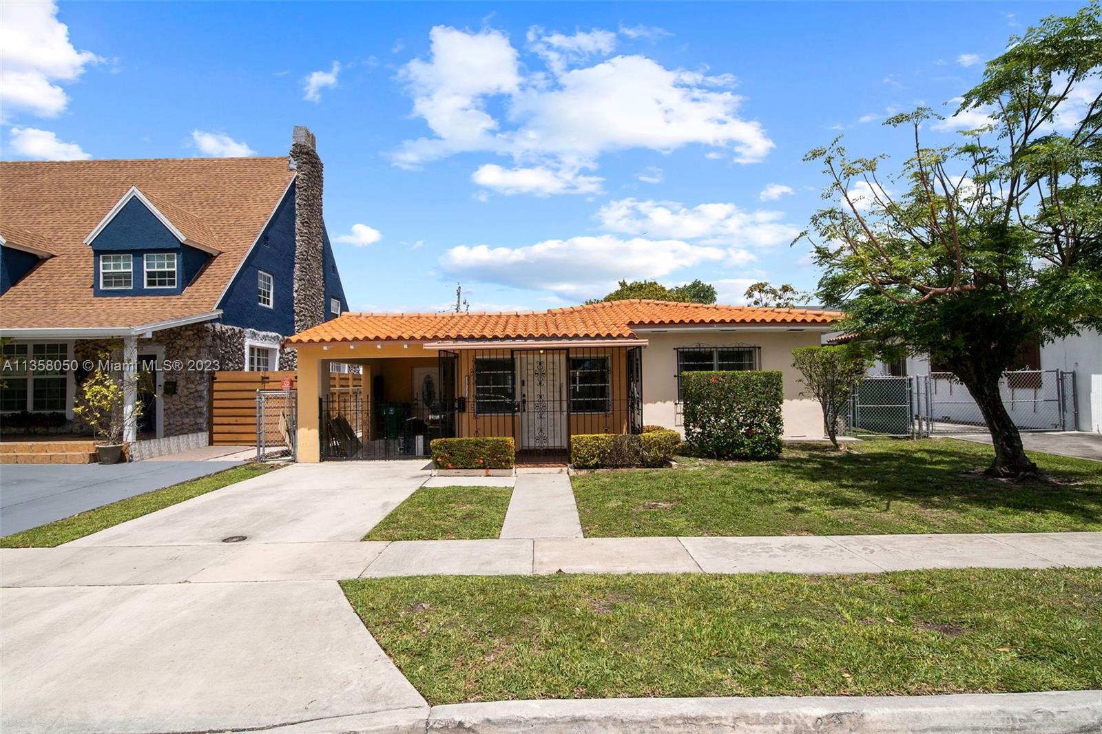 1911 Southwest 23rd Street Miami, FL 33145 - Photo 1 of 48 a front view of a house with a yard garage and outdoor seating