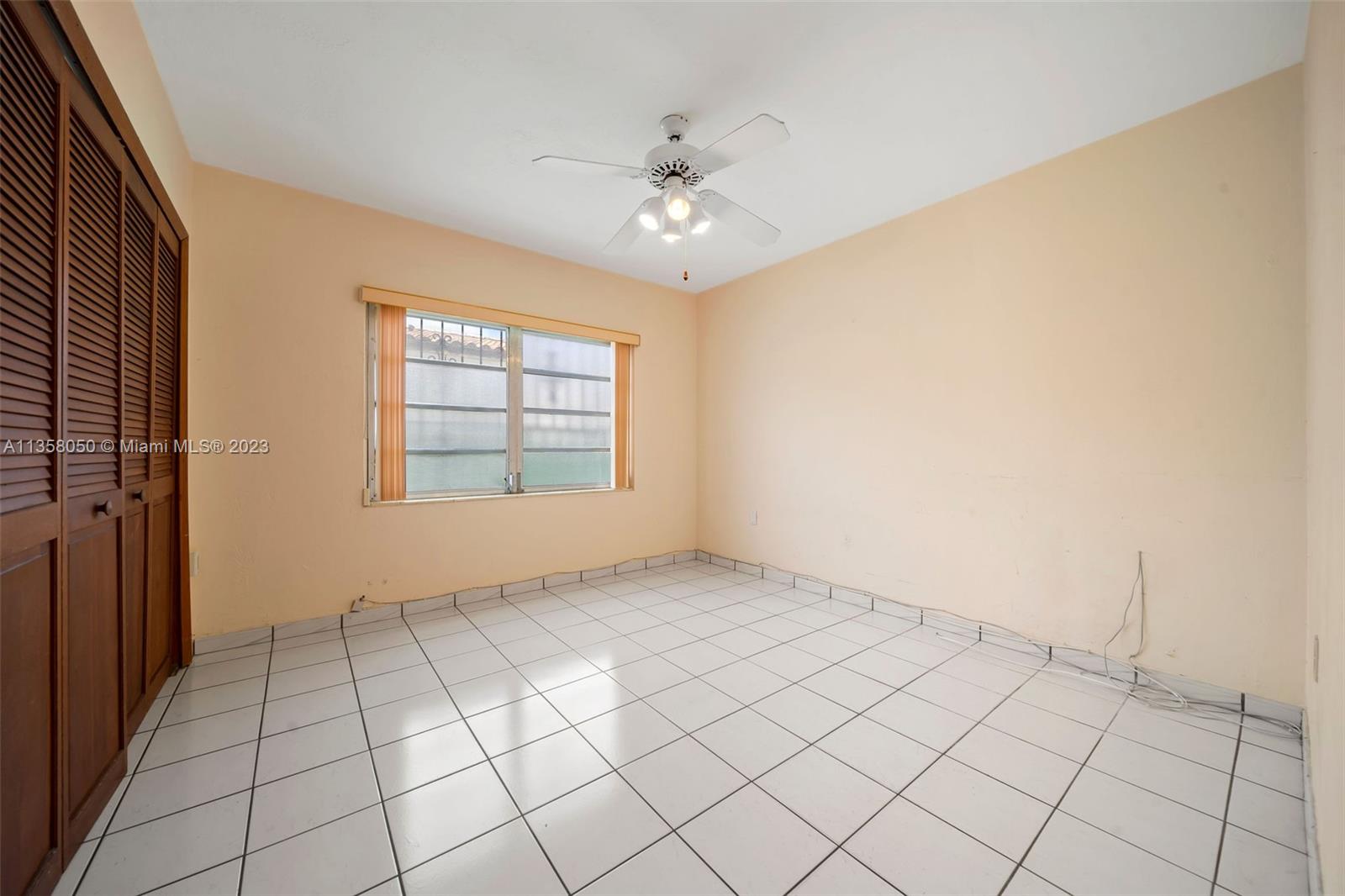 1911 Southwest 23rd Street Miami, FL 33145 - Photo 13 of 48 an empty room with windows and ceiling fan