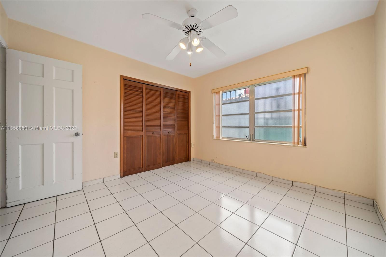 1911 Southwest 23rd Street Miami, FL 33145 - Photo 14 of 48 a view of an empty room with windows and chandelier fan