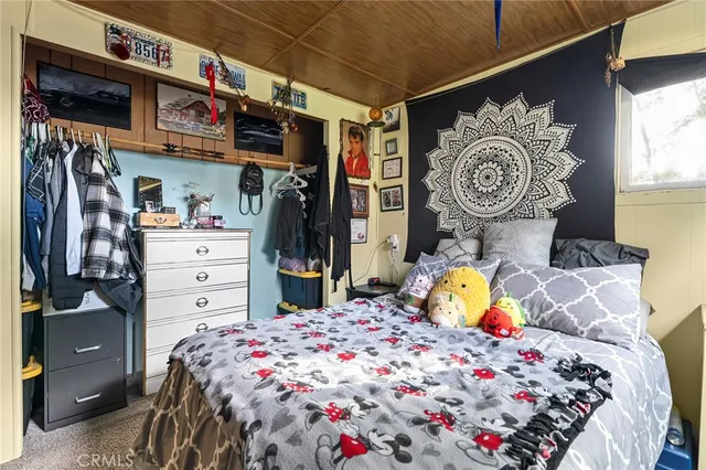 a bedroom with a bed and a flat screen tv in it