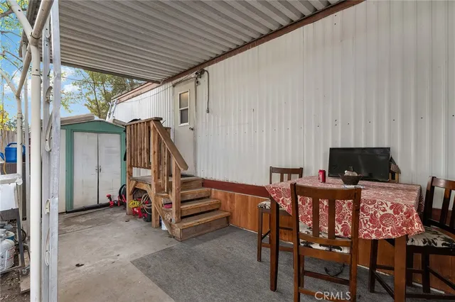 a view of a patio with table and chairs and wooden fence