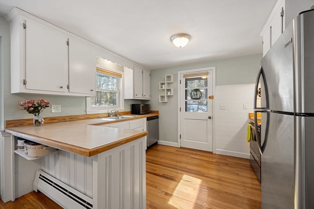 6 Cross Street Foxboro, MA 02035 - Photo 4 of 26 a kitchen with stainless steel appliances granite countertop a refrigerator a sink dishwasher a stove and white countertops with wooden floor