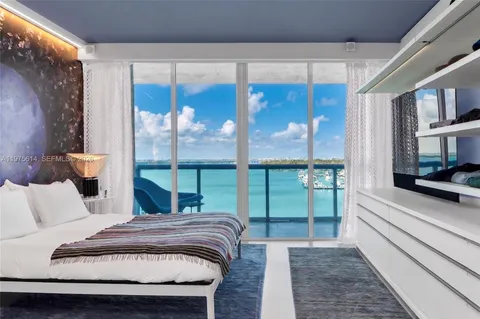 a bedroom with a bed and a large window