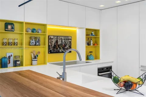 a living room with stainless steel appliances furniture a flat screen tv and a large window