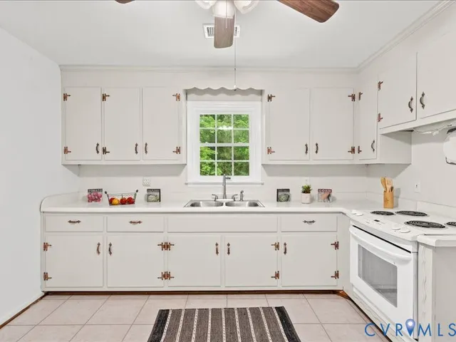 a kitchen with cabinets appliances a sink and a window