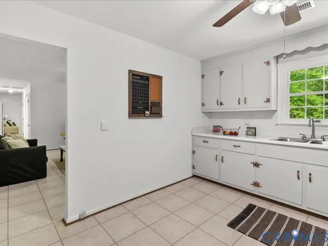 a view of a bedroom with wooden floor and a ceiling fan