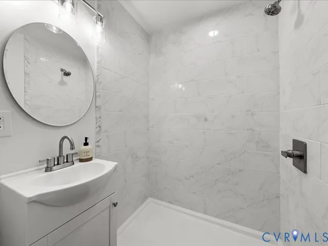 a bathroom with a sink a shower and a mirror