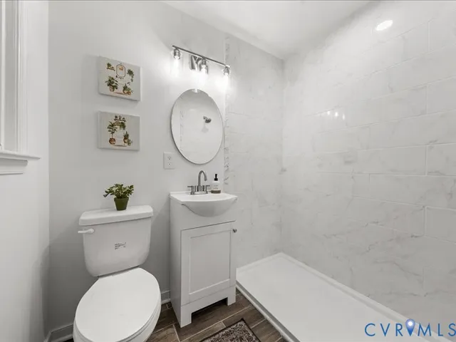 a bathroom with a toilet a sink and mirror