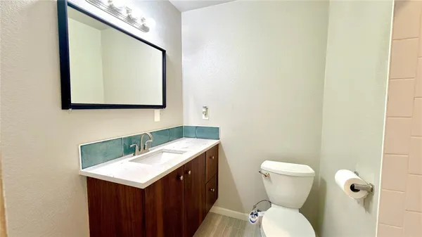 a bathroom with a toilet sink and mirror