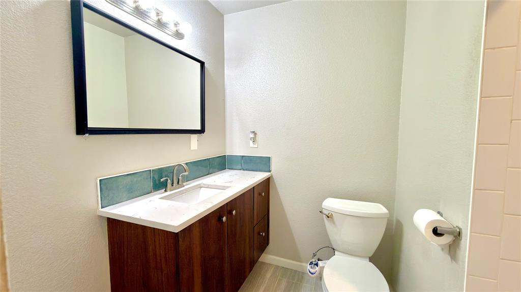 2510 Dewitt Street Irving, TX 75062 - Photo 8 of 17 a bathroom with a toilet sink and mirror